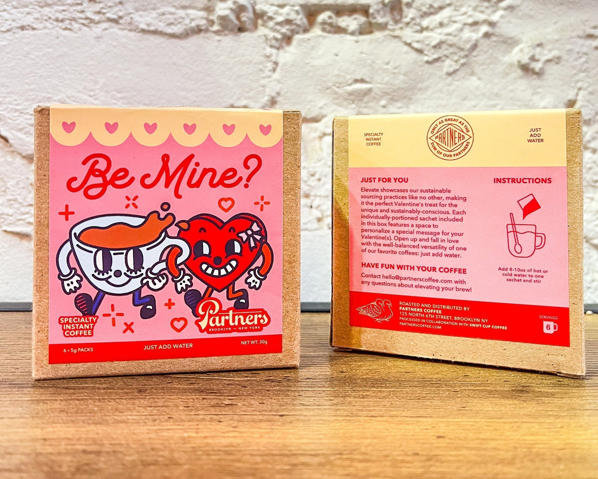 Front-and-back view of Partners Coffee Be Mine? instant coffee boxes with pink Valentine’s packaging and cartoon cup and heart