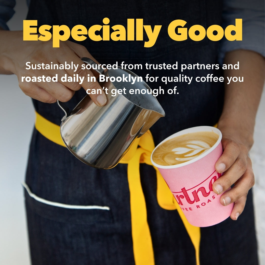 Person pouring milk into a pink Partners Coffee cup with latte art, wearing an apron with a yellow tie; overlaid headline “Especially Good”