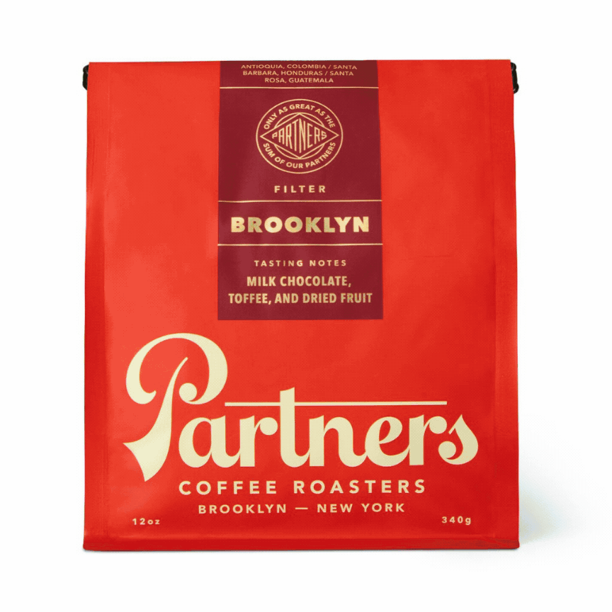 Front view of Mainstay Shuffle coffee bag with red Partners Brooklyn packaging and milk chocolate, toffee, and dried fruit notes