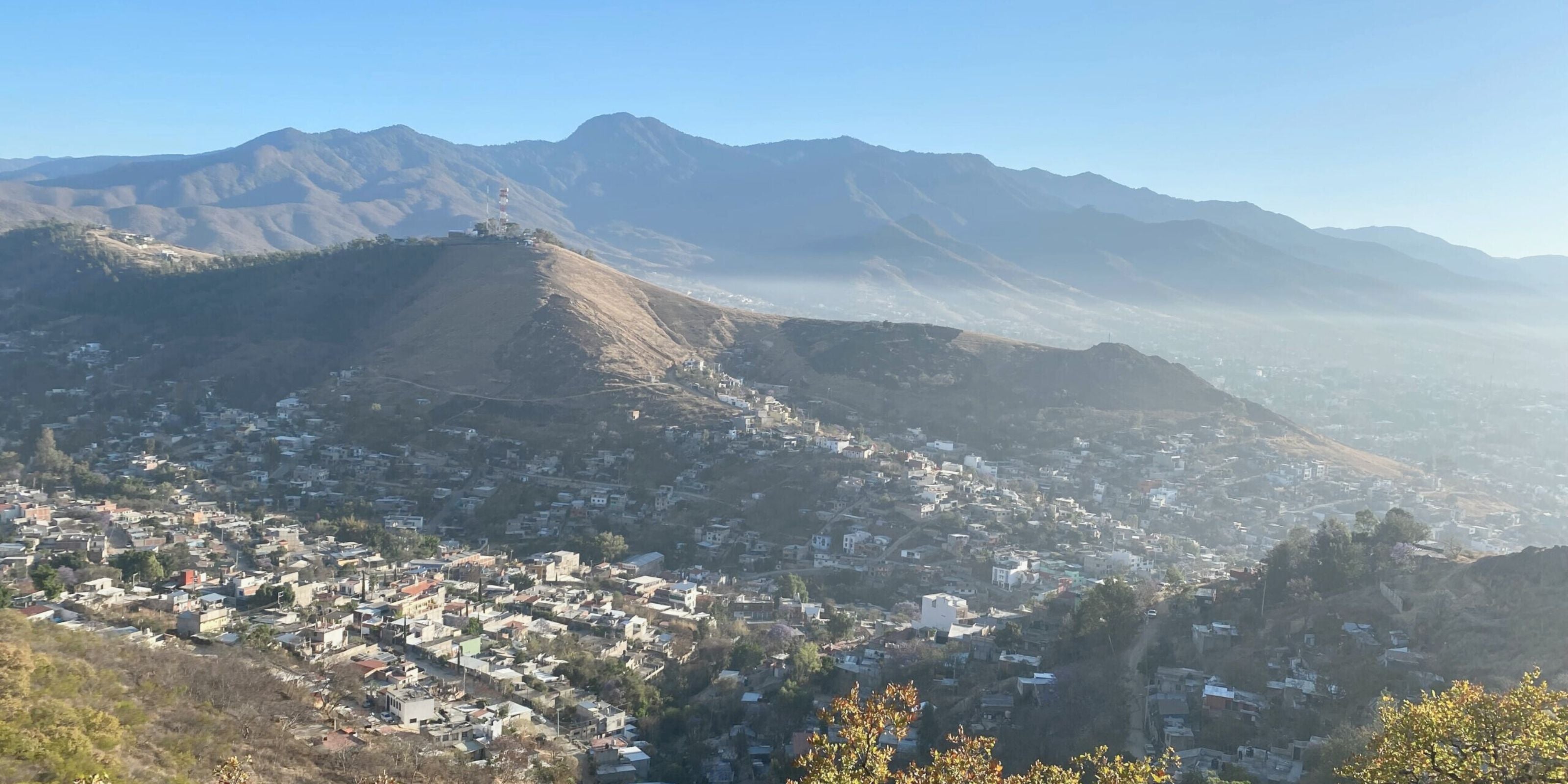 Mountainous town of San Vicente Yogondoy in the Sierra Sur of Oaxaca, viewed from a hillside with rugged ridges behind it