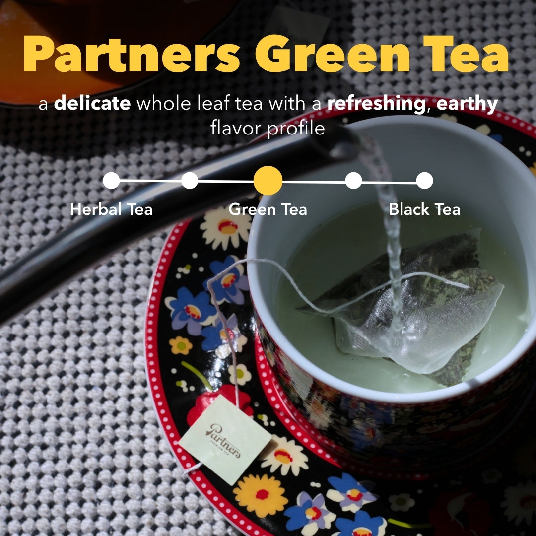Partners Green Tea steeping in a floral cup, described as delicate, refreshing, earthy whole leaf tea